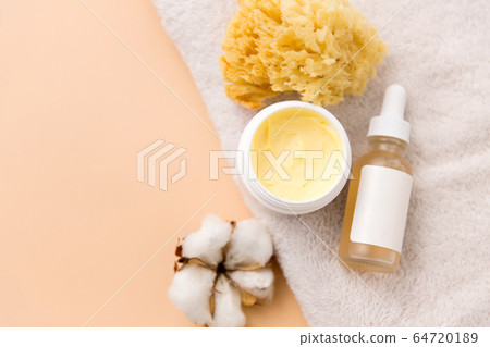 body butter, essential oil, sponge on bath towel 64720189