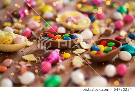 chocolate eggs and candy drops on wooden table chocolate eggs and candy drops on wooden table 64720234