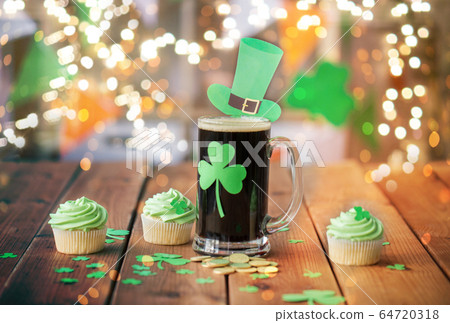 shamrock on beer glass, green cupcakes and coins shamrock on beer glass, green cupcakes and coins 64720318