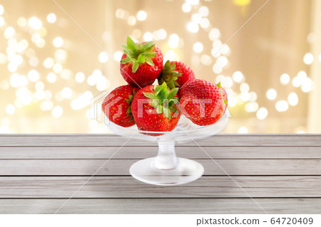 strawberries on glass stand over lights background strawberries on glass stand over lights background 64720409
