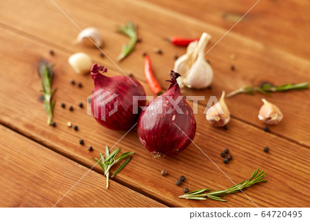 onion, garlic, chili pepper and rosemary on table 64720495
