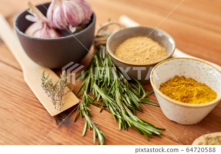 spices, rosemary, wooden spatula and garlic 64720588