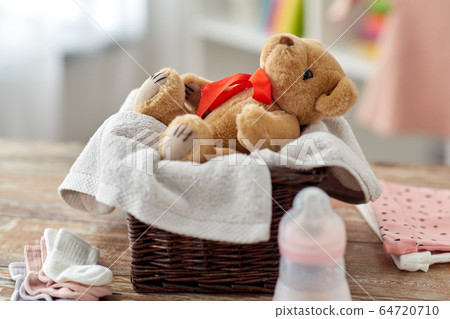 teddy bear toy in basket with baby things on table teddy bear toy in basket with baby things on table 64720710