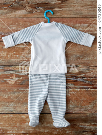 baby clothes set with hanger on wooden table 64720849