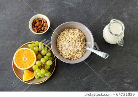 oatmeal with fruits, almond nuts and jug of milk oatmeal with fruits, almond nuts and jug of milk 64721029