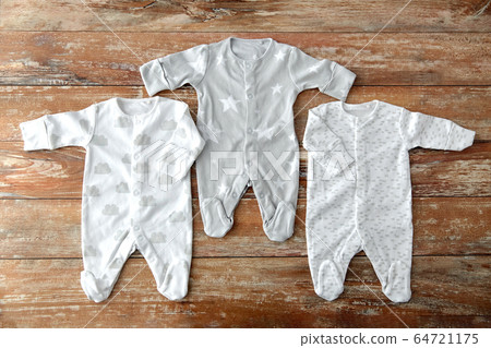 baby clothes set of bodysuits on wooden table baby clothes set of bodysuits on wooden table 64721175