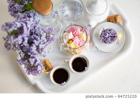 Breakfast with black tea or coffee and sweet meringue kisses on the white table. Breakfast with black tea or coffee and sweet meringue kisses on the white table. 64725220