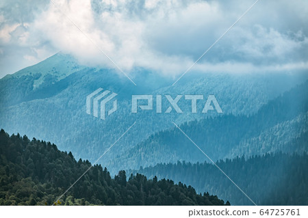High mountains with green slopes in dense fog. High mountains with green slopes in dense fog. 64725761