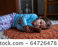 Cute little girl lying down looking at mobile 64726478