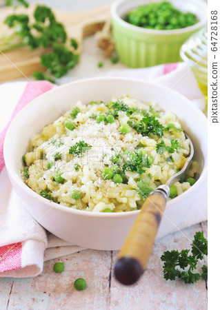 Italian cuisine. Plate of green pea risotto with parmesan cheese, olive oil and parsley Italian cuisine. Plate of green pea risotto with parmesan cheese, olive oil and parsley 64728168