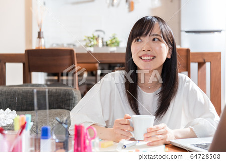 Young woman drinking coffee at home in the morning 64728508