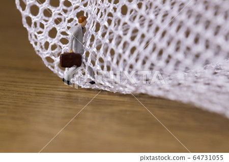 Businessman trying to get out of the mesh 64731055