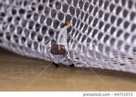 Businessman trying to get out of the mesh 64731072