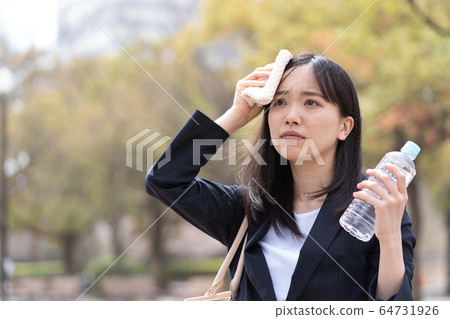 A young woman wiping sweat 64731926