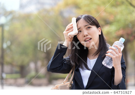 A young woman wiping sweat 64731927