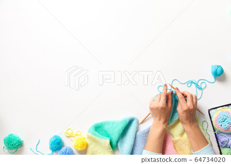 Women crochet and knitting from colored yarn. Top view. 64734020