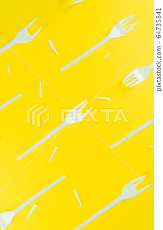 Pattern of broken plastic forks on a yellow background. Pattern of broken plastic forks on a yellow background. 64735841