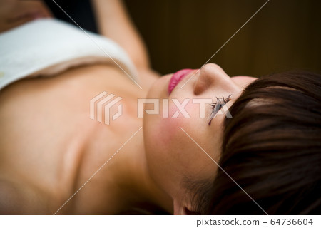 Young woman receiving a massage at an esthetic cut Young woman receiving a massage at an esthetic cut 64736604