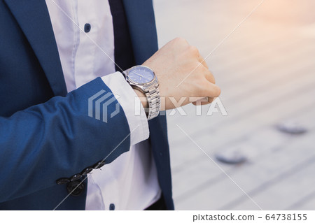 The photo close up of businessman watching his The photo close up of businessman watching his 64738155