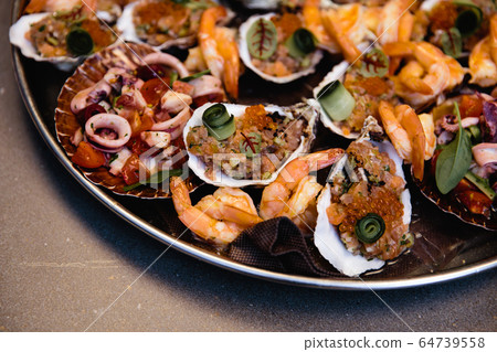 Assorted seafood, mussels, squid, scallops, salmon fillet and tiger shrimps with garlic creamy sauce, parmesan cheese and basil Assorted seafood, mussels, squid, scallops, salmon fillet and tiger shrimps with garlic creamy sauce, parmesan cheese and basil 64739558
