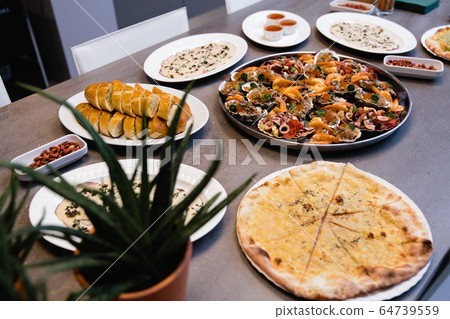 Assorted seafood, mussels, squid, scallops, salmon fillet and tiger shrimps with garlic creamy sauce, parmesan cheese and basil Assorted seafood, mussels, squid, scallops, salmon fillet and tiger shrimps with garlic creamy sauce, parmesan cheese and basil 64739559