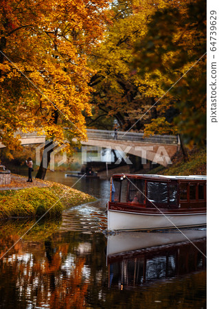 Golden autumn canal with a boat in the centre of Riga, Latvia Golden autumn canal with a boat in the centre of Riga, Latvia 64739629