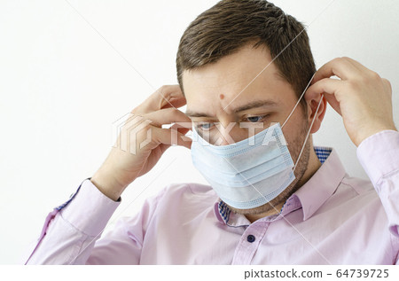 Coronavirus. Quarantine. A man in a shirt puts on Coronavirus. Quarantine. A man in a shirt puts on 64739725