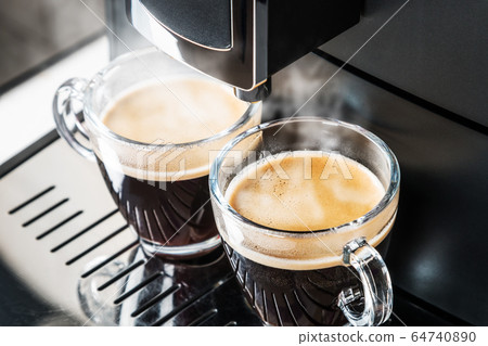 glass cups of hot espresso are being prepared in the coffee machine glass cups of hot espresso are being prepared in the coffee machine 64740890