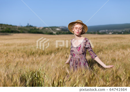 Portrait of a beautiful fashionable woman in a field harvesting 64741984