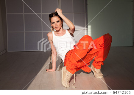 Beautiful woman with braids dances to music orange Beautiful woman with braids dances to music orange 64742105