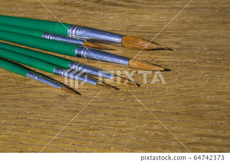 Paint brushes and colored paper 64742373