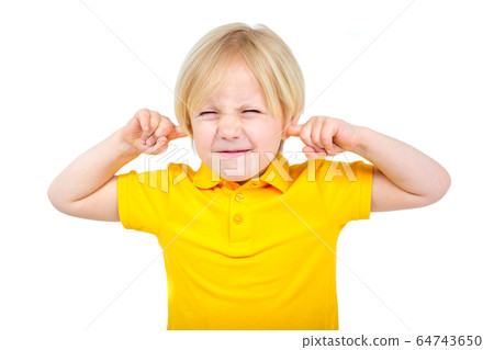 Annoyed boy covers his ears with fingers 64743650