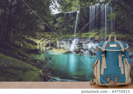 Backpack and beautiful waterfall landscape background. 64750915