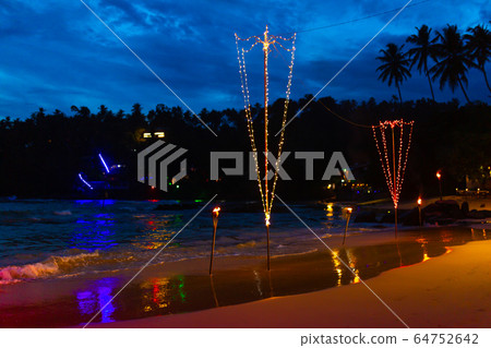 Oceanfront restaurant with lights and tables on a Oceanfront restaurant with lights and tables on a 64752642