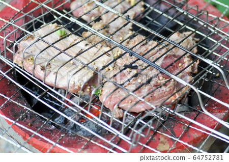 grilled beef and grilled pork on the stove 64752781