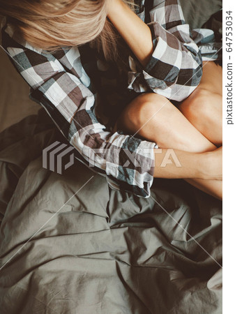 Young female in casual shirt on the bed Young female in casual shirt on the bed 64753034