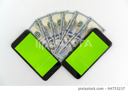 two mobile devices with chromakey and hundred dollar bills 64753237