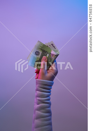 Hand holding banknotes on violet background. Hand holding banknotes on violet background. 64756858