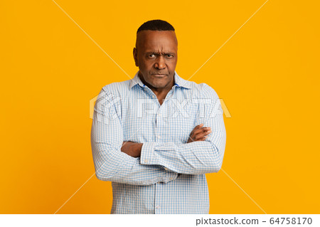 Grumpy mature african american man looking at camera Grumpy mature african american man looking at camera 64758170