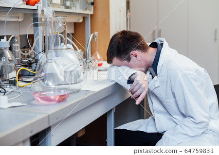 Male scientist sleeps in medical chemical lab 64759831