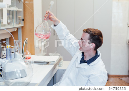 male scientist conducts chemical experiments in medical science laboratory male scientist conducts chemical experiments in medical science laboratory 64759833