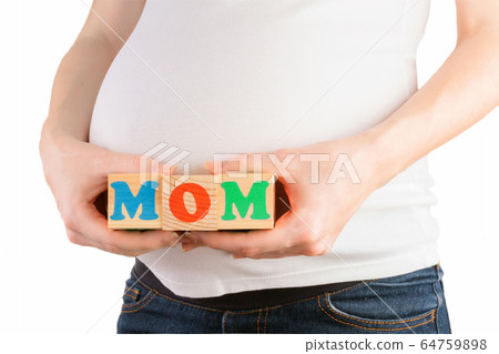 Pregnant woman belly with hands holding colorful wooden blocks with mom sign 64759898