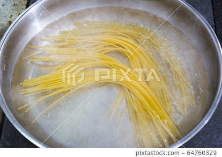 Cooking pasta in a pan. Close-up shot in the kitchen. Cooking pasta in a pan. Close-up shot in the kitchen. 64760329