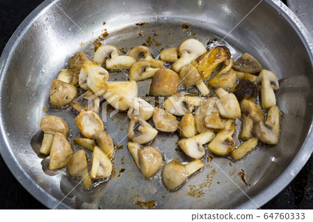 Cooking mushrooms in a pan. Close-up shot. Cooking mushrooms in a pan. Close-up shot. 64760333