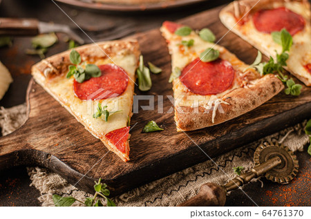 Homemade salami pizza with cheese corners 64761370