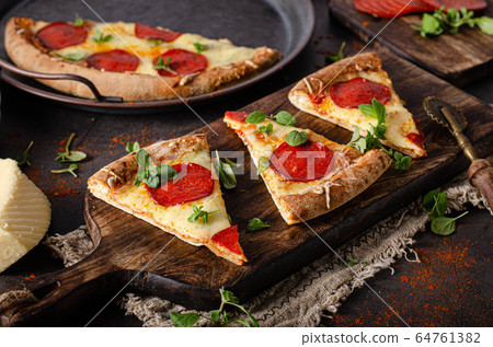 Homemade salami pizza with cheese corners Homemade salami pizza with cheese corners 64761382