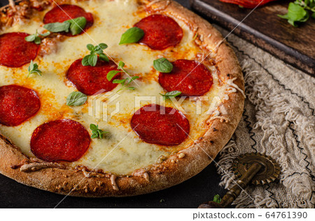 Homemade salami pizza with cheese corners Homemade salami pizza with cheese corners 64761390