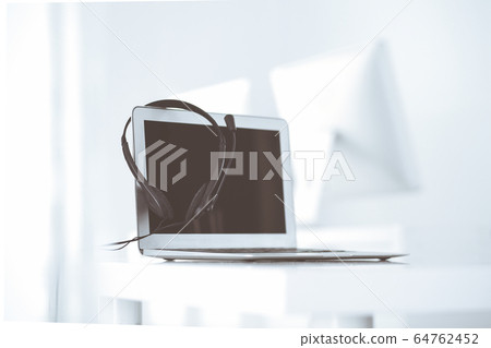 Call center and communication support, customer service help desk. VOIP headset on laptop computer 64762452