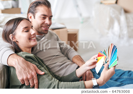 Happy young woman with toothy smile showing her husband color palette Happy young woman with toothy smile showing her husband color palette 64763008
