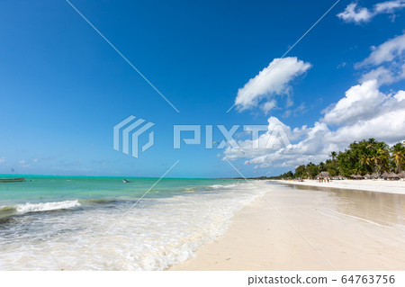 White sand and blue sky spread over Paje beach in Zanzibar, Tanzania 64763756